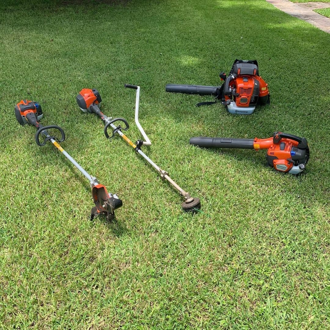Commercial lawn care and mowing equipment, including Husqvarna weed eater, blower, and edger used by Evergreen Outdoor Services.