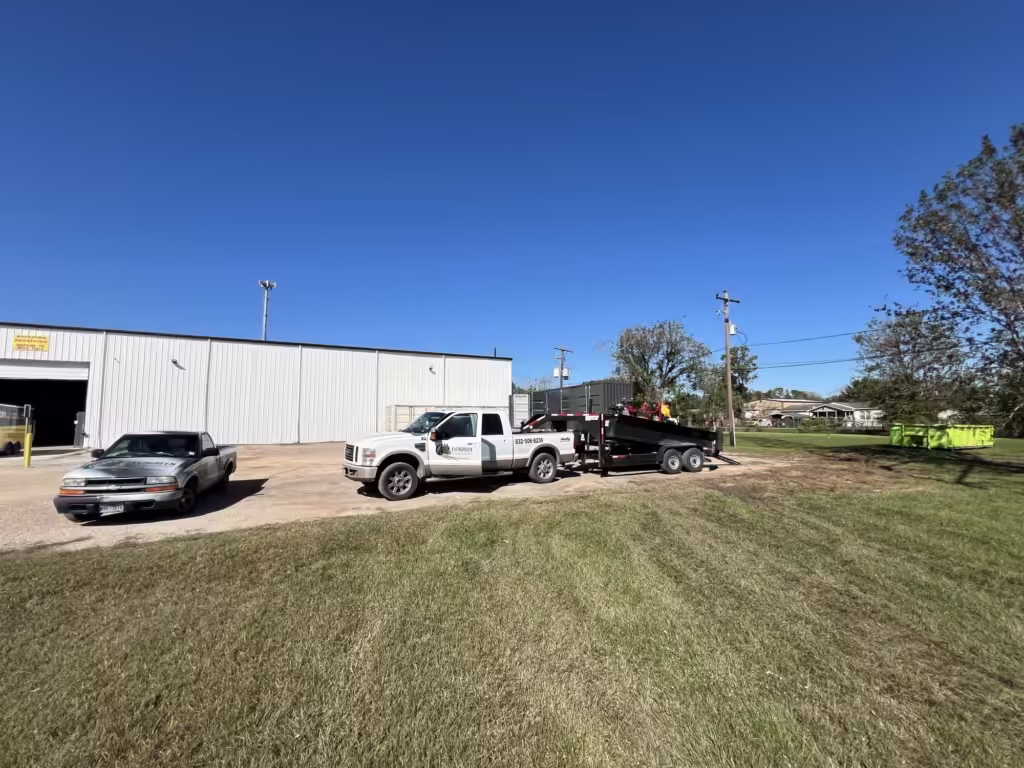 Branded Lawn care trucks with grass in the foreground and warehouse in the backgorund