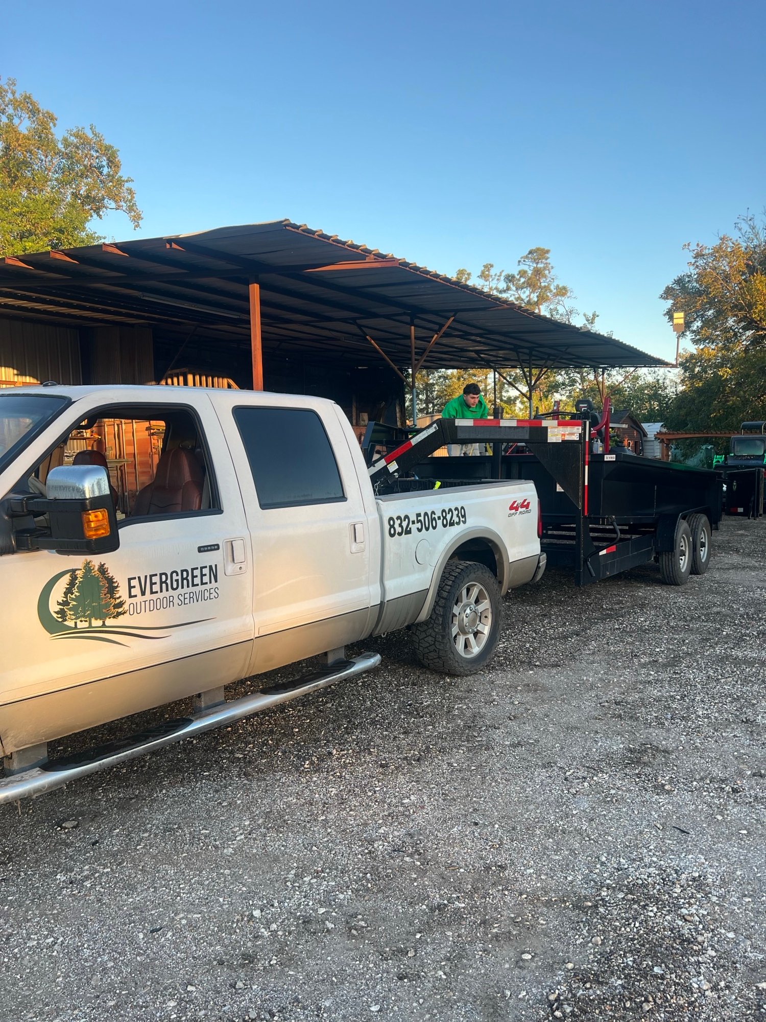 Commercial lawn mowing truck and trailer being prepped at the shop, loaded with equipment and ready to begin the day’s mowing route