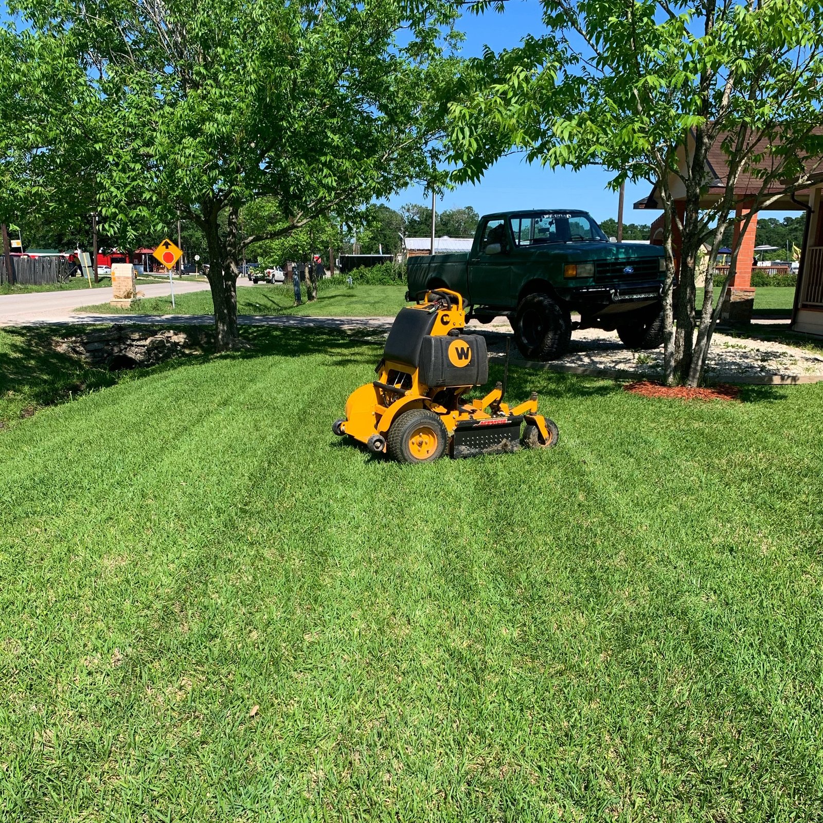 Commercial lawn mower on a freshly mowed front lawn, showcasing clean, even grass for a professional finish