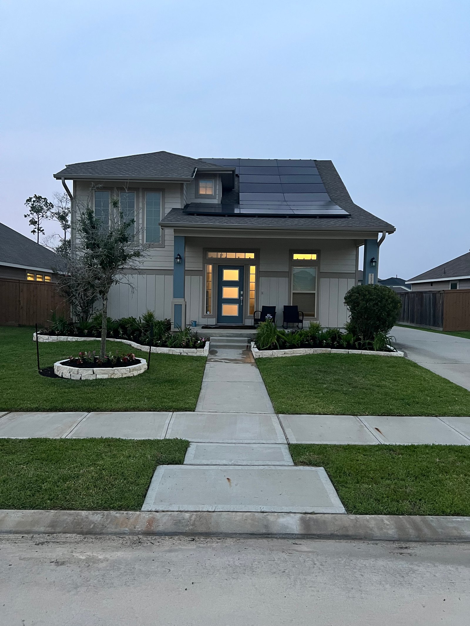 Houston home with freshly installed sod, clean garden beds, trimmed hedges, and colorful plants showcasing a move-in-ready lawn. Ideal curb appeal for real estate resale and added property value.