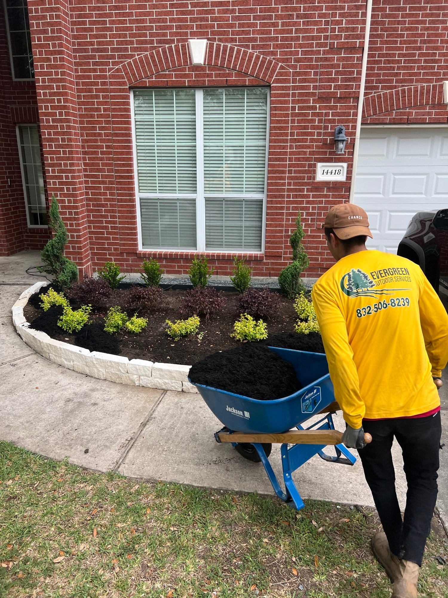 Front garden bed with natural mulch and newly installed landscape features in the Summerwood neighborhood