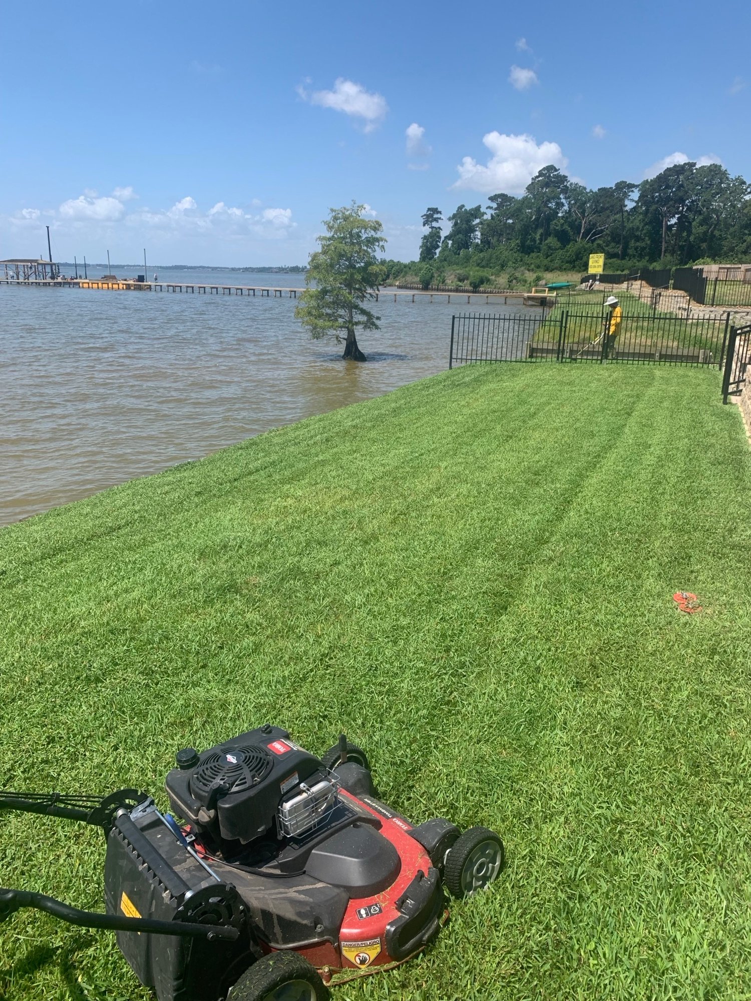 LAWN MOWING IN HUMBLE TEXAS BACKYARD WITH BACKGROUND OF LAKE HOUSTON
