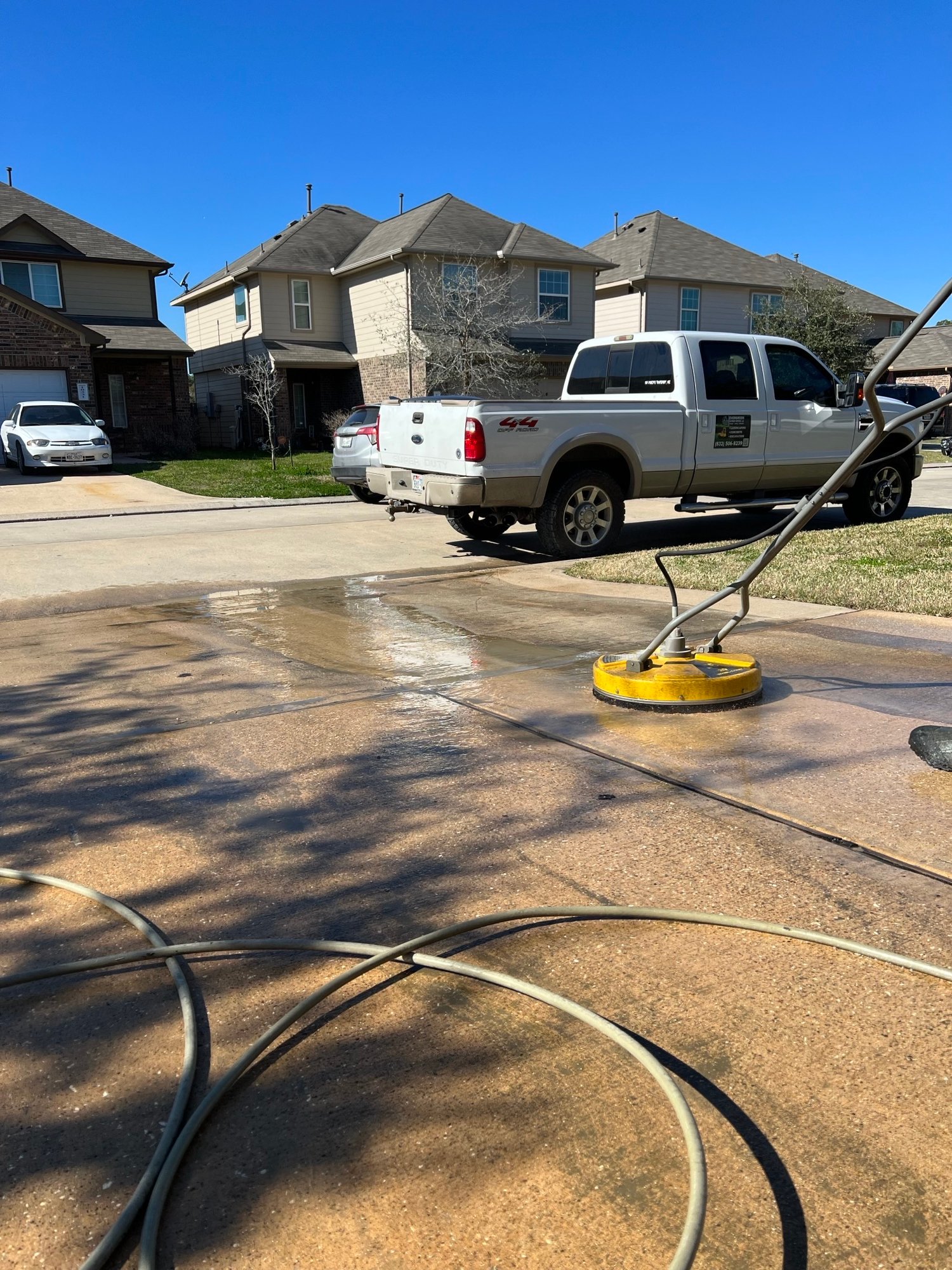 Driveway being pressure washed in Houston with surface cleaner