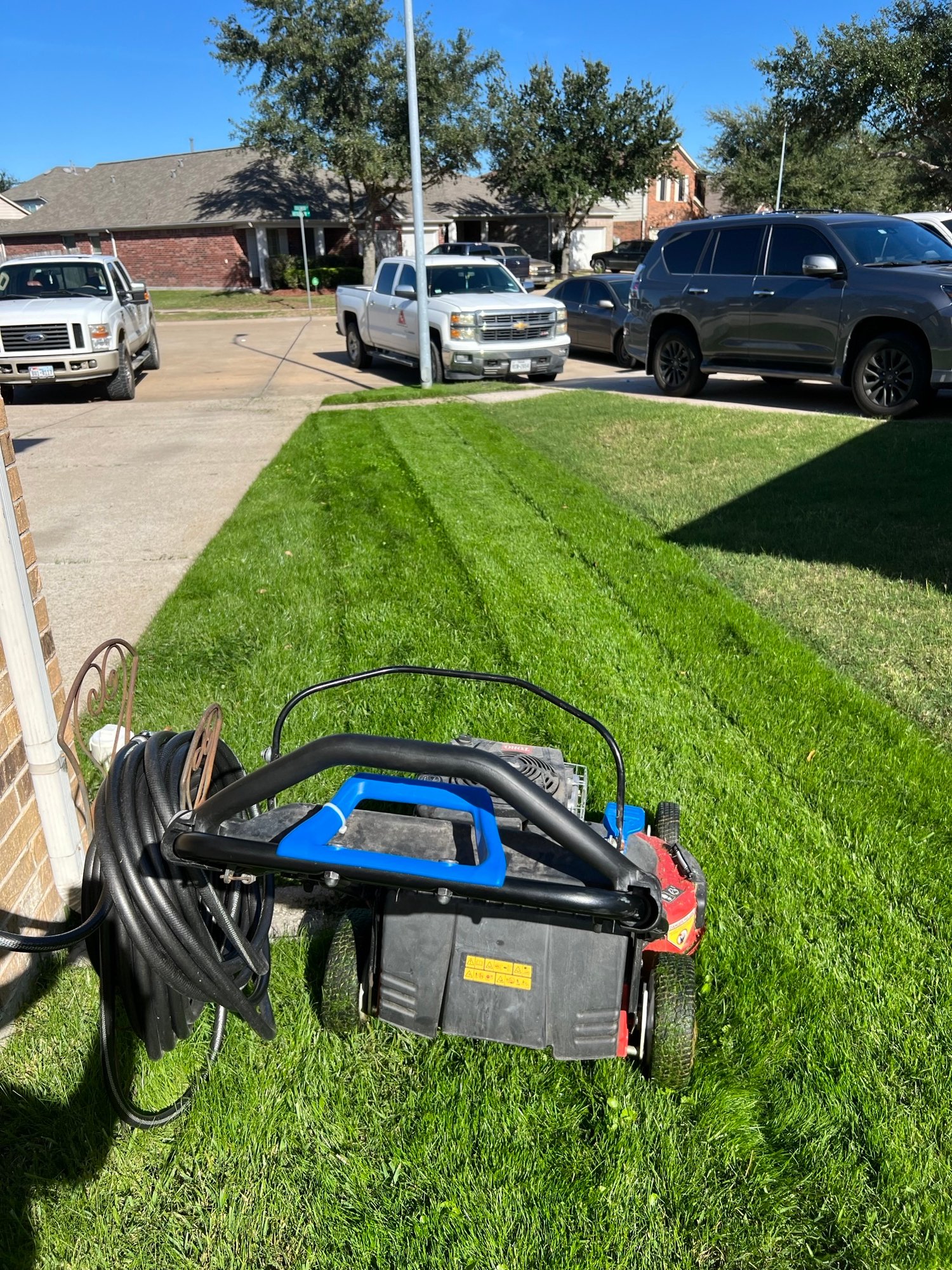 Professional using a Toro Time Master mower to create neat stripes on a green rye grass front lawn.