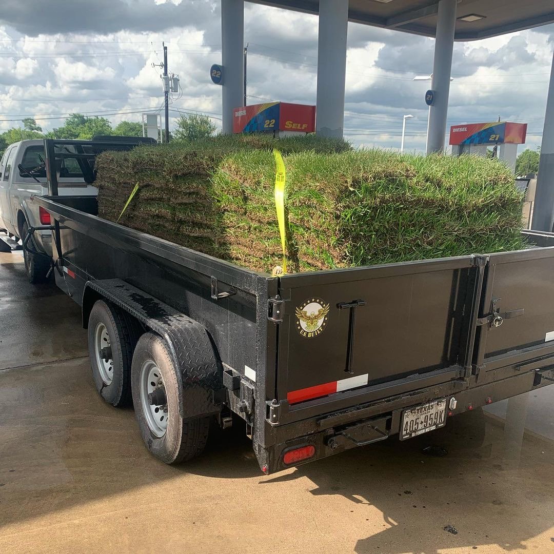 Fresh sod loaded onto a trailer, ready for installation – Neatly stacked rolls of lush green grass prepared for a professional lawn transformation.