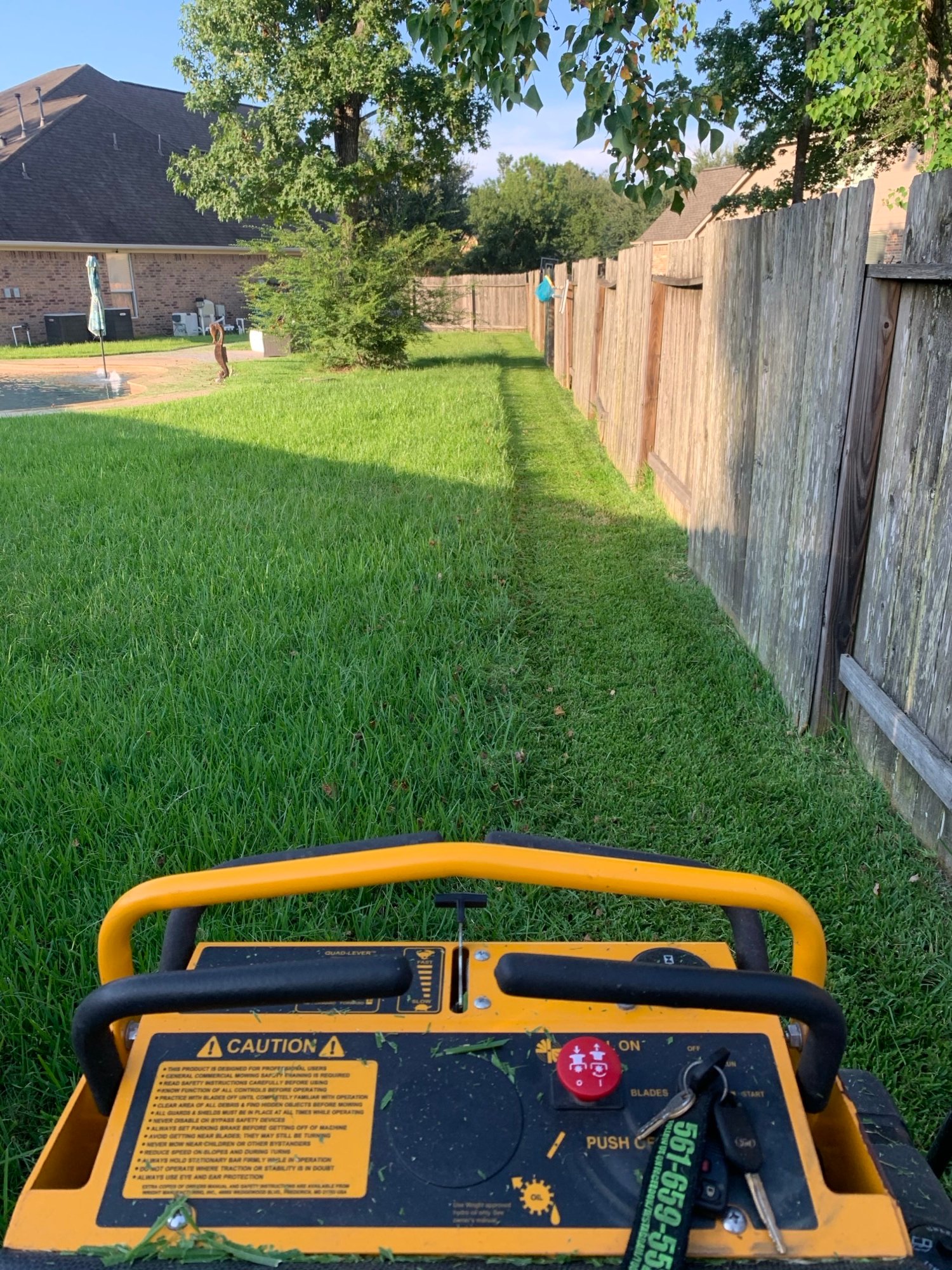 Lawn care service in atascocita, tx being performed for a suburban backyard