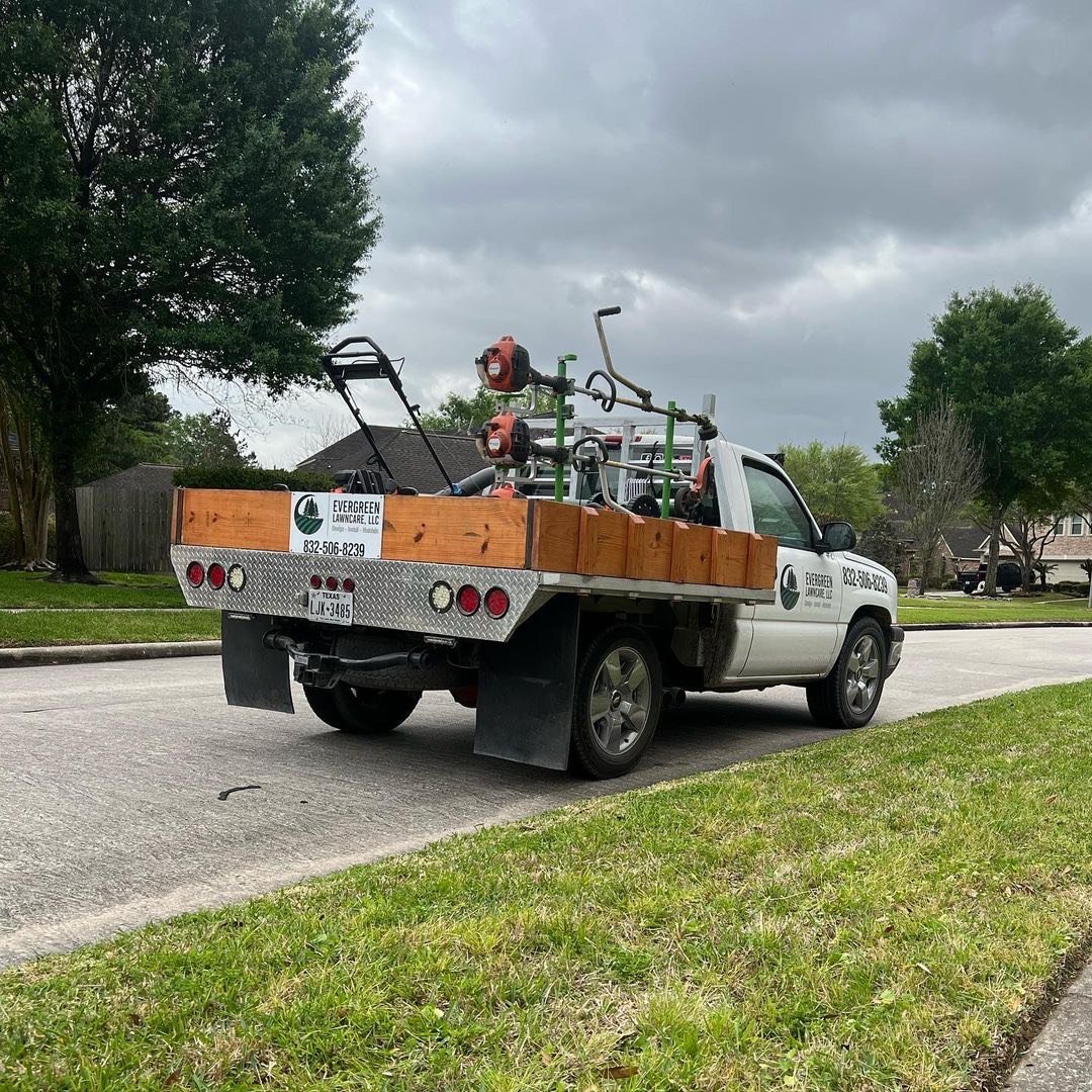 Evergreen Lawn Care professionally branded truck and mowing setup parked on-site at a Houston residential property, ready for expert lawn service.