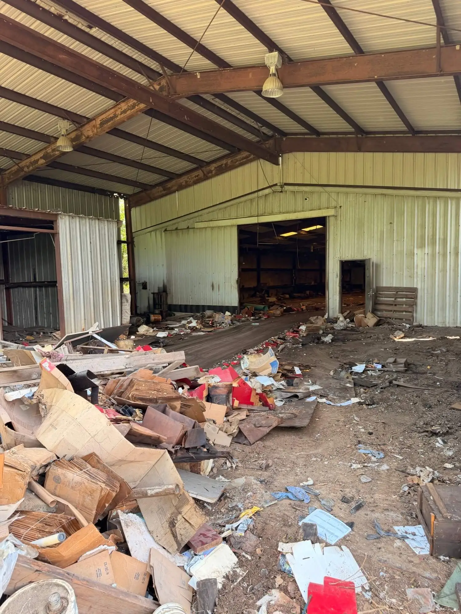 Debris-filled warehouse interior before a large property reset and cleanup in Houston