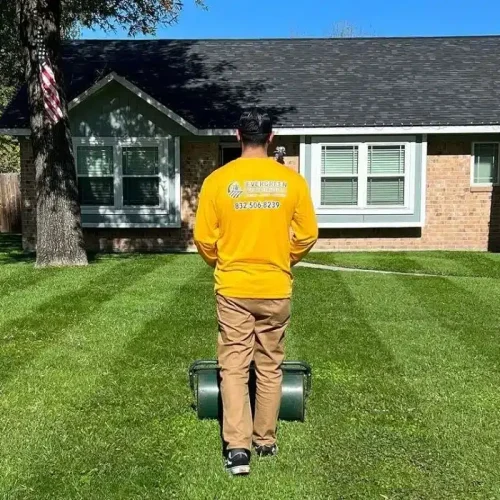 Evergreen Outdoor Services crew working on a well-kept suburban lawn in Kingwood, Texas — delivering professional results with Satisfaction Guaranteed.